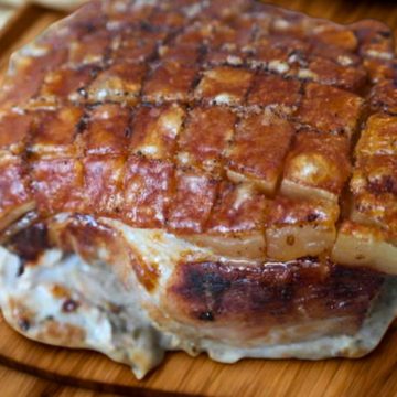 Bavarian pork roast with crispy crackling on a wooden board.